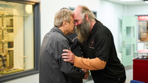 Two people with their foreheads pressed together in a Maori greeting